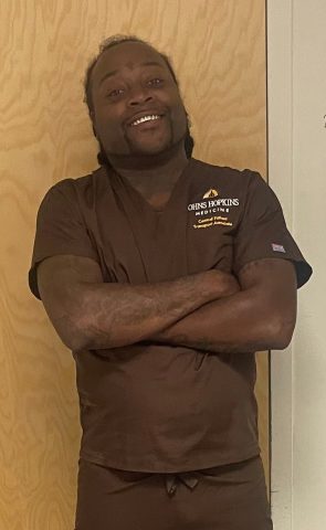 Isaac Jackson III wearing a brown Johns Hopkins uniform.