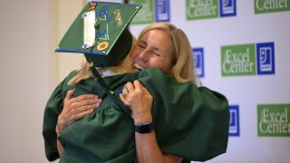 Graduate and staff member hug at graduation