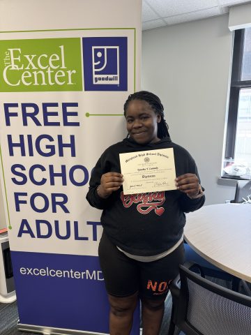 Tyeeshia C holding her diploma visiting the Excel Center as an alumni