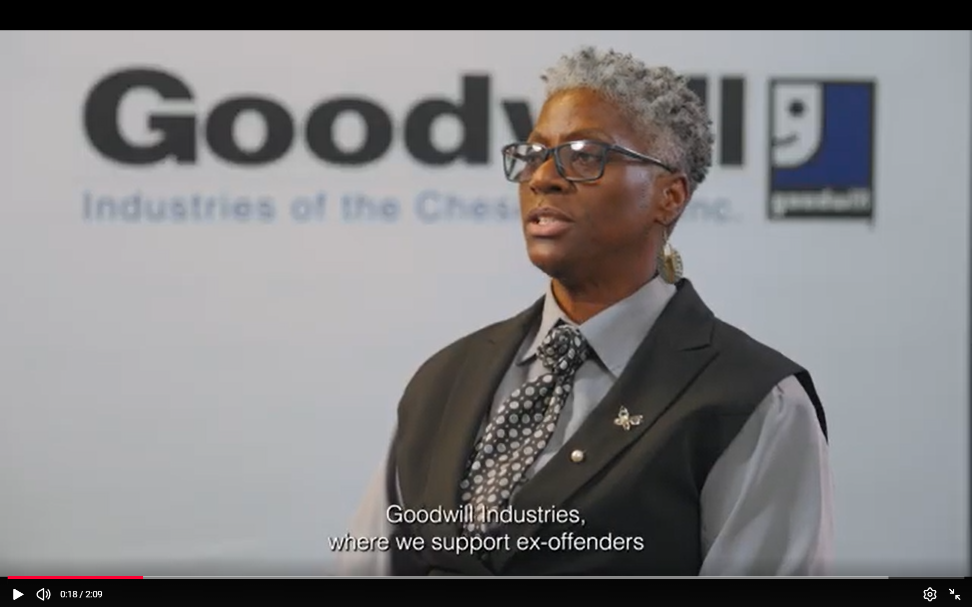 Skills Trainer Shelly Tyndale-Brown sits in front of Goodwill branded background