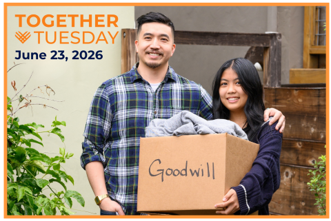 A couple smiles while holding a cardboard box labeled "Goodwill," ready to make a donation for Together Tuesday on June 23rd, 2026.